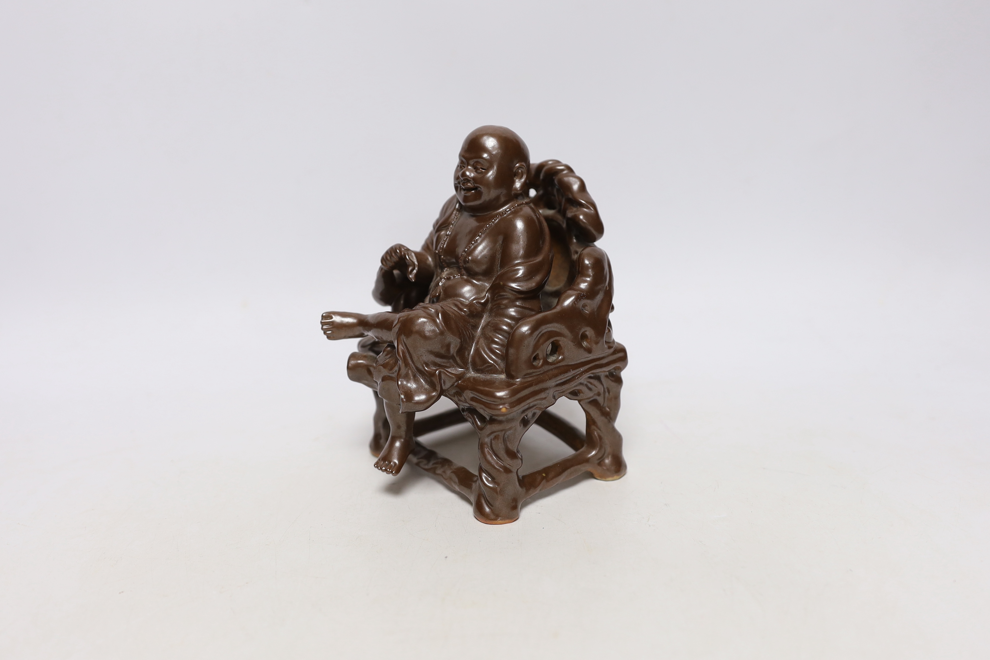 A late 19th/ early 20th century Chinese porcelain faux bronze figure of Budai seated on a throne, 15cm high, Provenance - Owned by the same family prior to 1980.